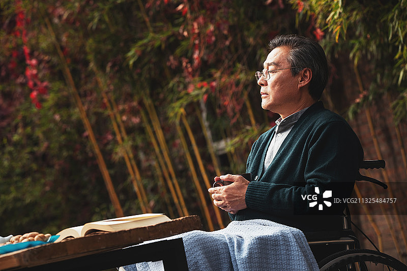 孤独的老年男人坐在院子里图片素材