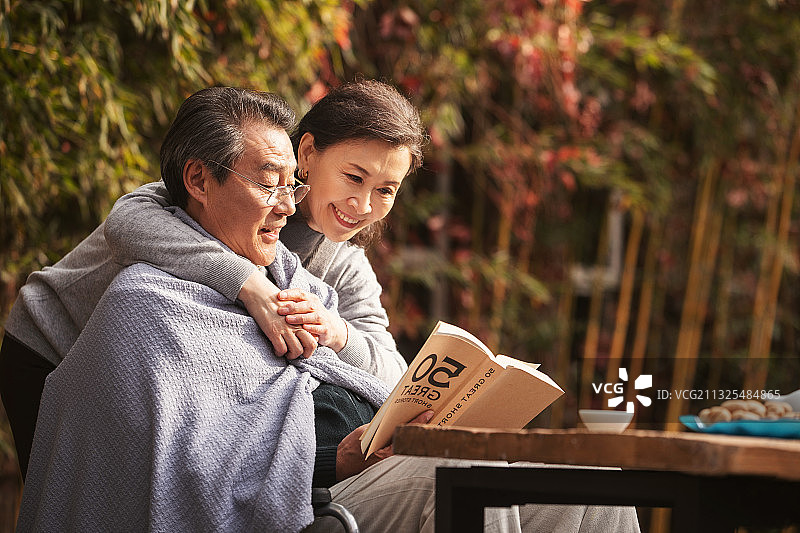 幸福的老年夫妇在户外看书图片素材