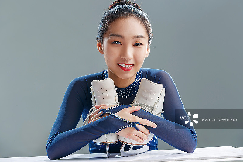 抱着冰刀鞋的年轻女人图片素材