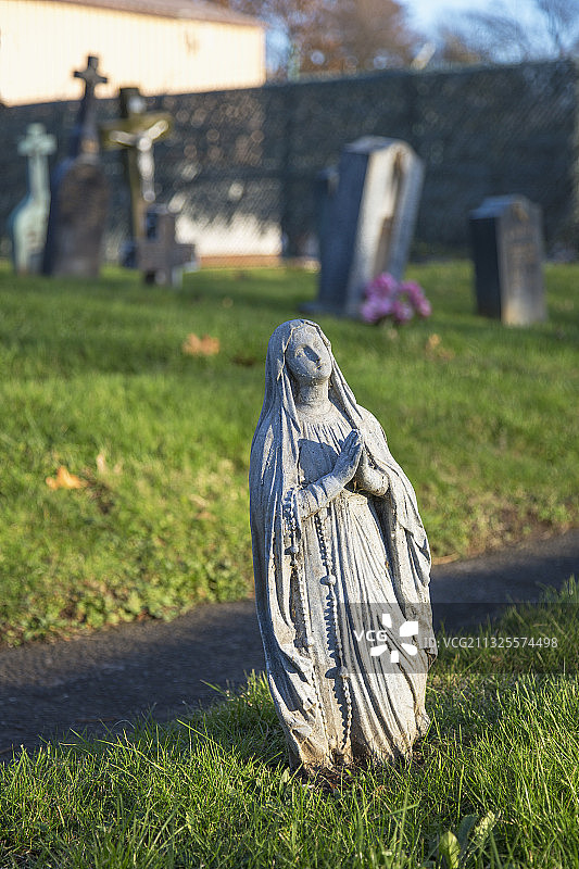 半掩埋的圣母玛利亚墓地雕像图片素材