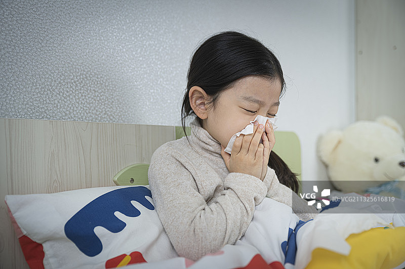 亚洲小女孩在床上擤鼻涕图片素材