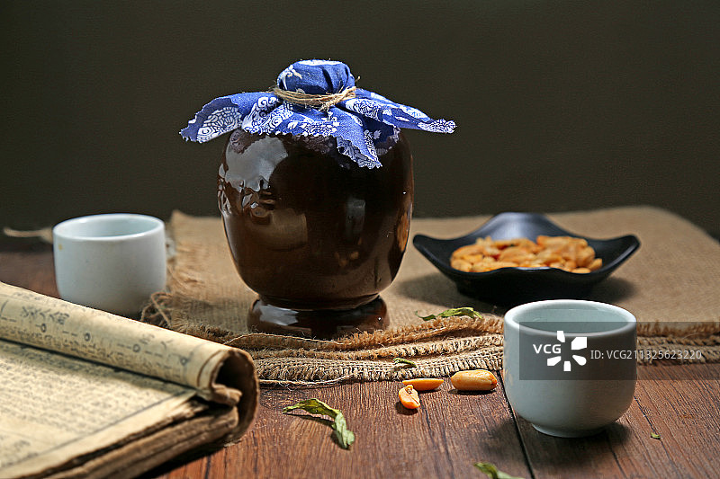 复古酒瓶和酒杯花生米放在木桌上图片素材