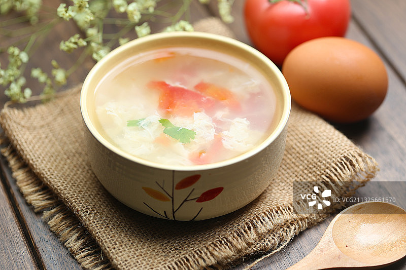西红柿鸡蛋汤和木勺放在粗麻布背景上图片素材
