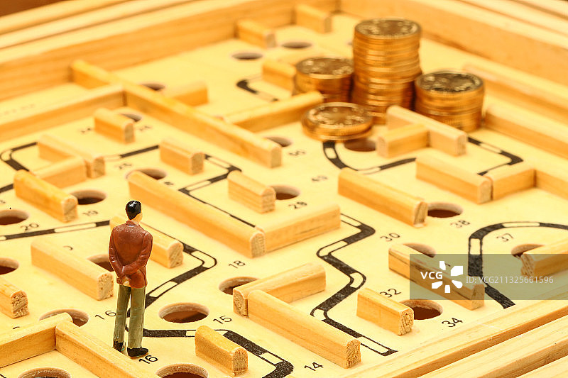 商务男人面对迷宫和硬币财富图片素材