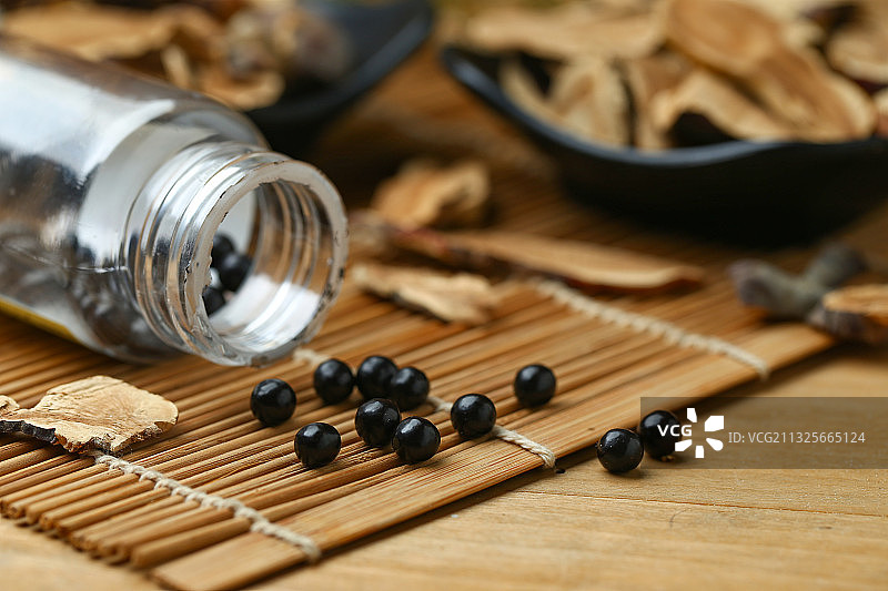 中成药丸和药瓶放在竹帘上图片素材
