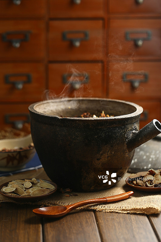 中药砂锅和中药碟子放在深色背景上图片素材