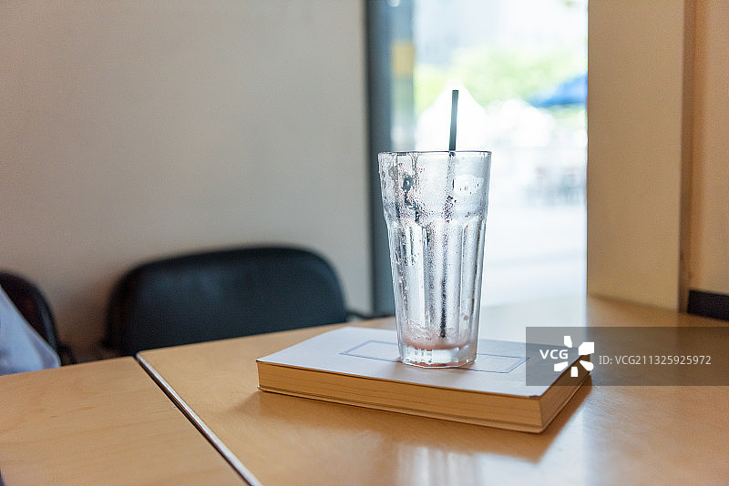 木桌上书本上的空饮料杯图片素材