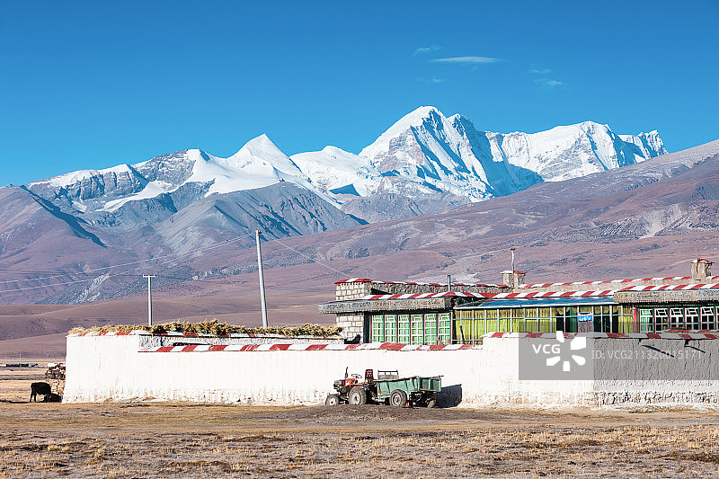 西藏当雄县的草原上的民居，远处是念青唐古拉山图片素材