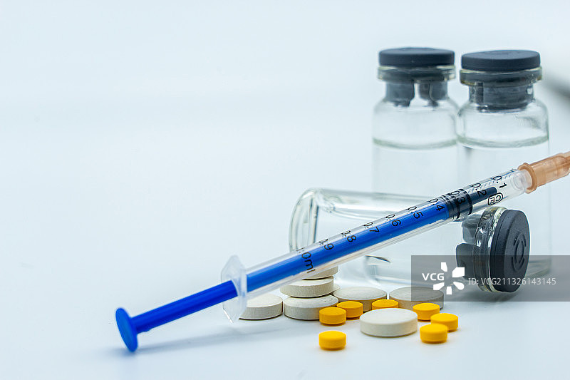 白色背景下的药片、疫苗和注射器针管图片素材