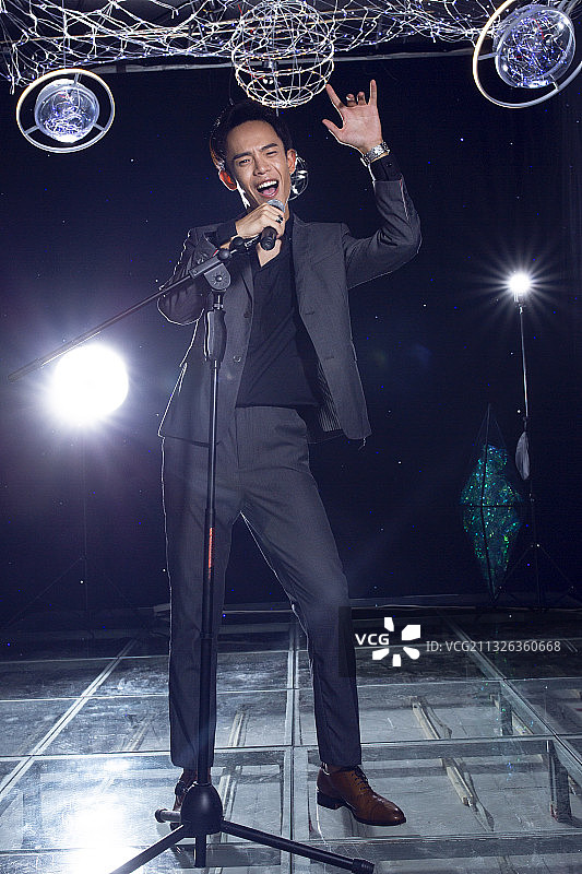 年轻歌手在舞台上唱歌图片素材