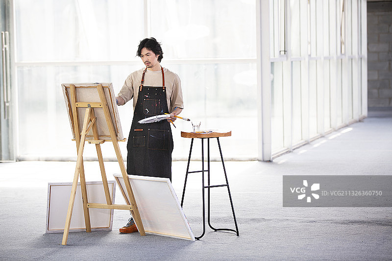 画家在工作室画油画图片素材