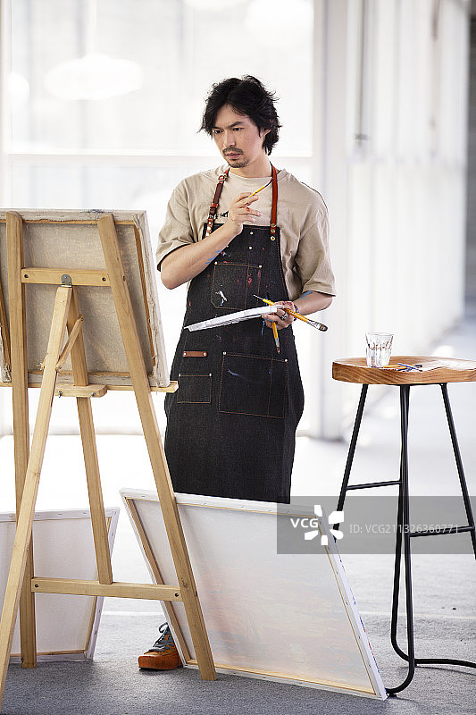 画家在工作室画油画图片素材