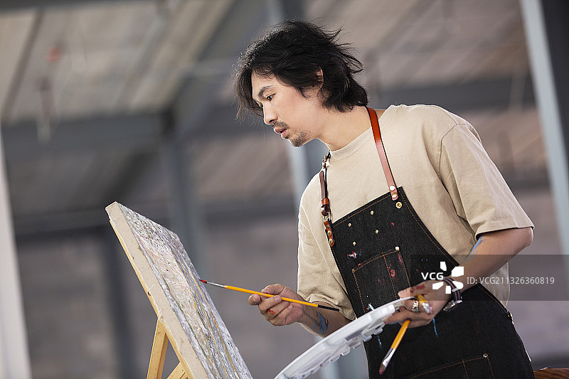 画家在工作室画油画图片素材