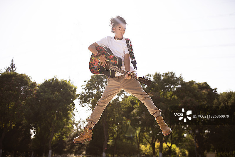 男子跳起弹奏吉他图片素材