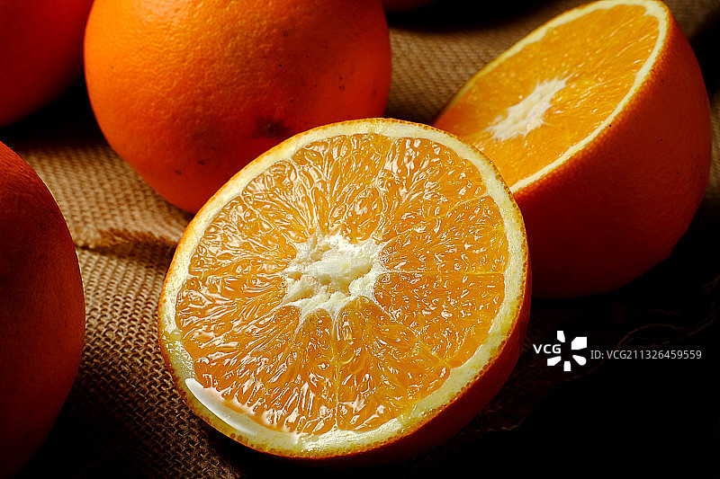 切开的橙子放在麻布背景上图片素材