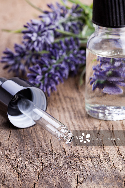 木桌上的玻璃瓶天然化妆油和薰衣草图片素材