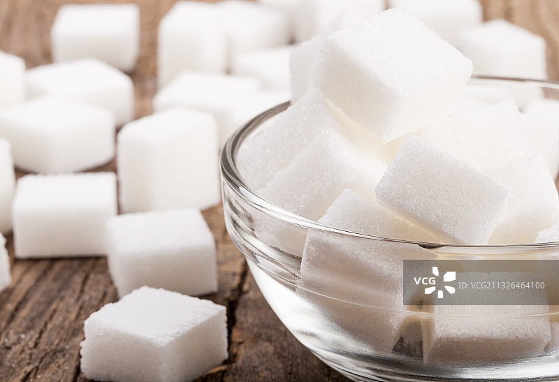 木桌上玻璃碗里的方糖特写图片素材