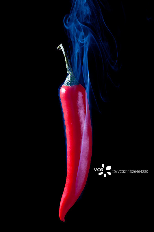 在黑色背景上冒烟的红辣椒图片素材
