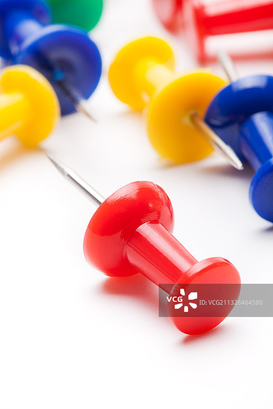 白色桌子上的彩色图钉图片素材