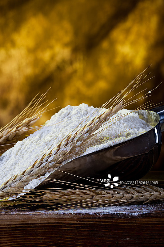 木桌上一堆面粉和小麦图片素材