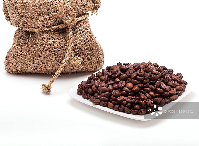 白色背景上散落出来的咖啡豆图片素材