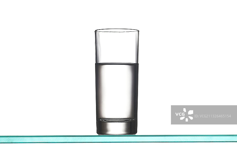 一杯冰水在玻璃板上图片素材