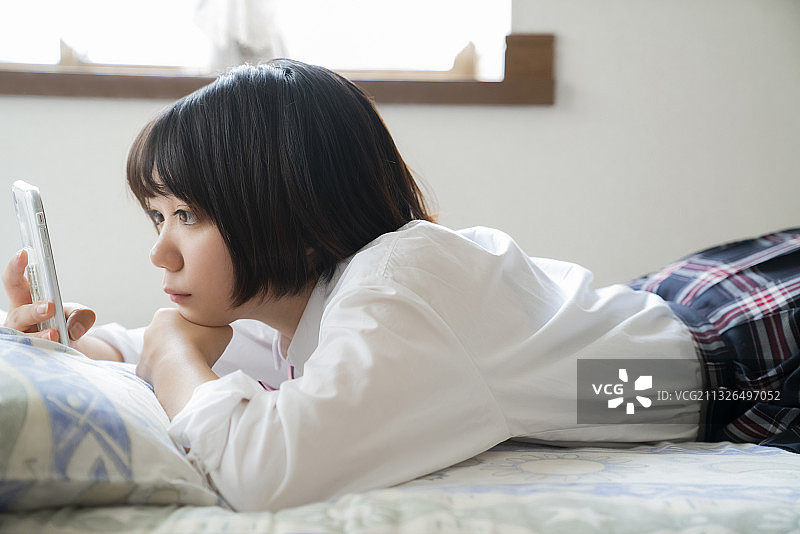 看智能手机的女学生图片素材
