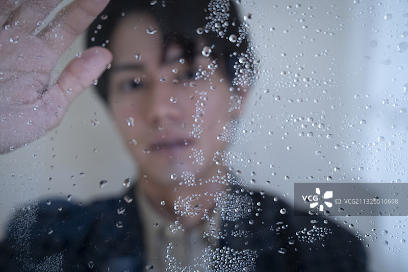 站在雨中窗边的男人肖像图片素材