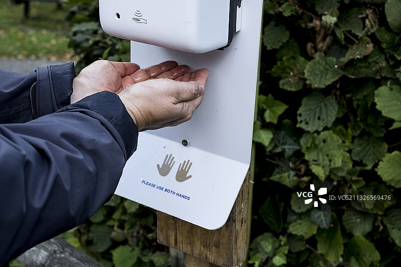 疫情期间使用自动洗手液机特写图片素材
