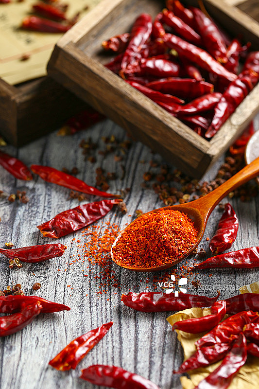 一勺辣椒粉和干辣椒放在木纹背景上图片素材