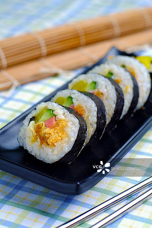 肉松蛋黄紫菜包饭放在黑色盘子里图片素材