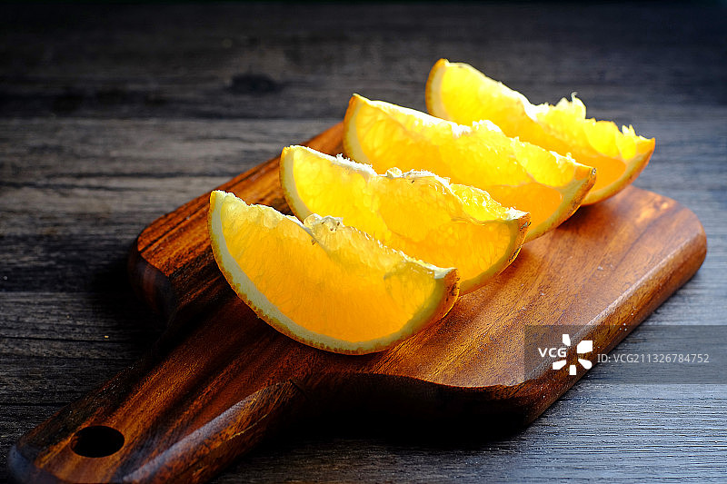 切开的橙子放在木板上图片素材
