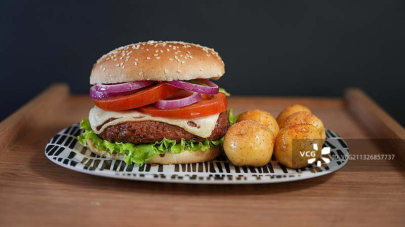 黑色背景下，砧板上的汉堡特写图片素材