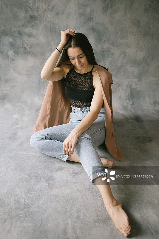 穿着黑色蕾丝衬衫和牛仔裤的年轻女人肖像，俄罗斯图片素材