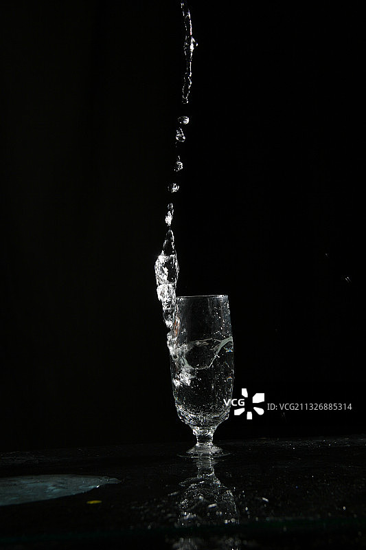 黑色背景下倾倒的水的特写图片素材