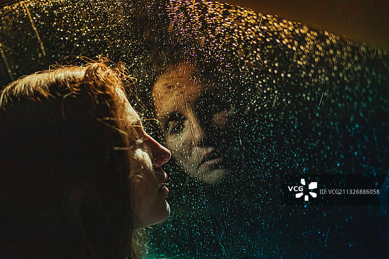 女人隔着湿玻璃窗向外看特写图片素材