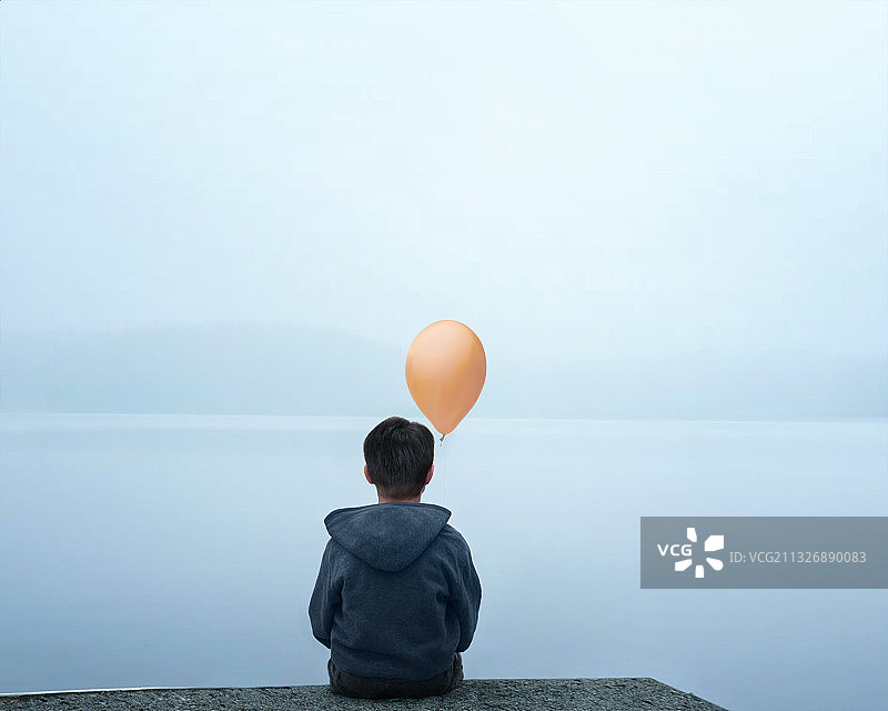 坐在水边拿着气球的人的背影图片素材