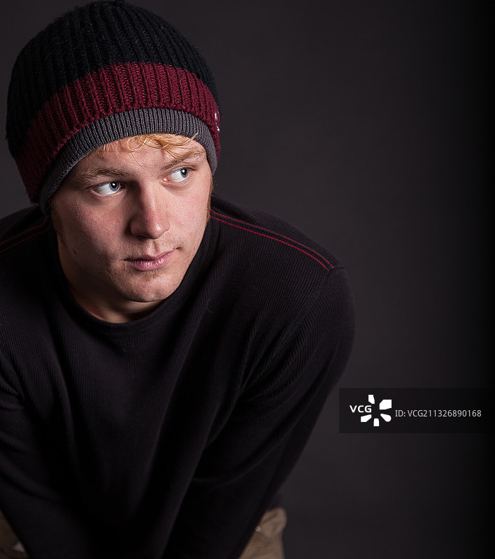 黑色背景下戴针织帽的男人肖像图片素材