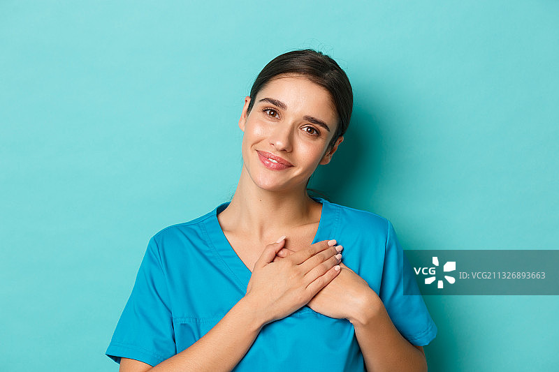 蓝色背景下的微笑的年轻女子肖像图片素材