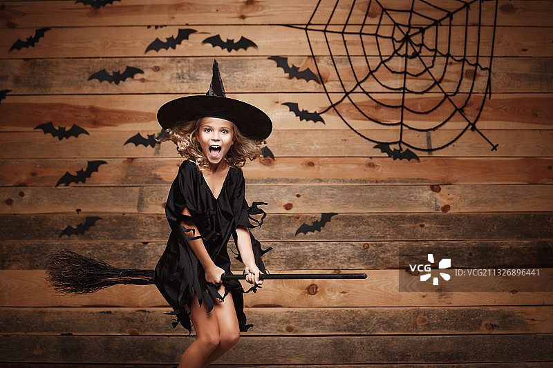 万圣节期间戴着女巫服装的女孩肖像图片素材