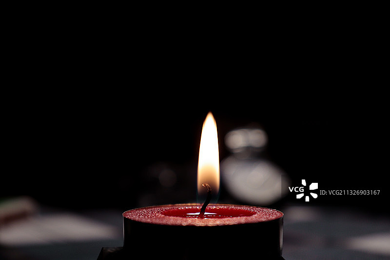 暗室中点燃的蜡烛的特写图片素材
