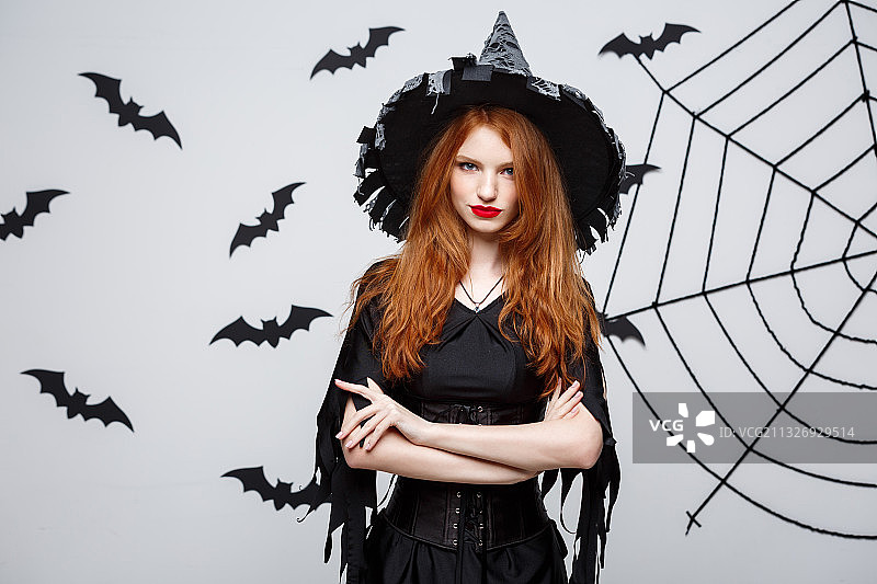 万圣节服装年轻女子站在白色背景前的肖像图片素材