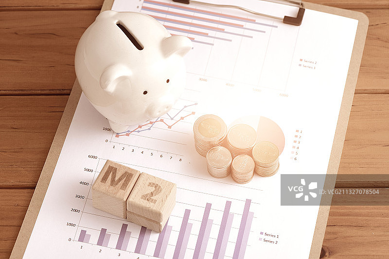 图表上摆放着硬币，储蓄罐和M2积木图片素材