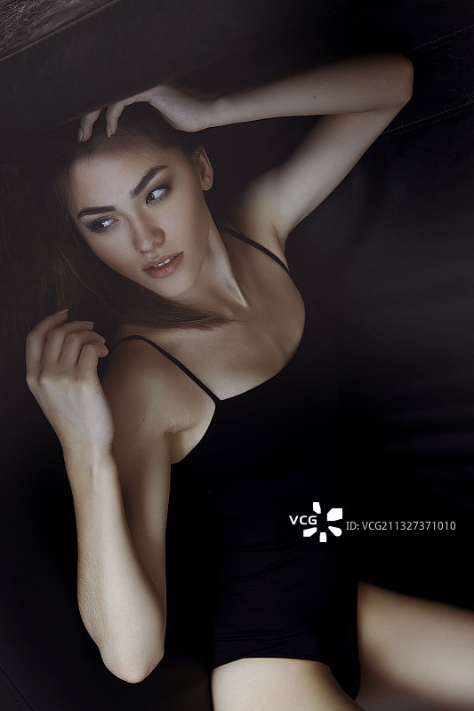 穿着黑色内衣的年轻漂亮成年女人躺在沙发上图片素材