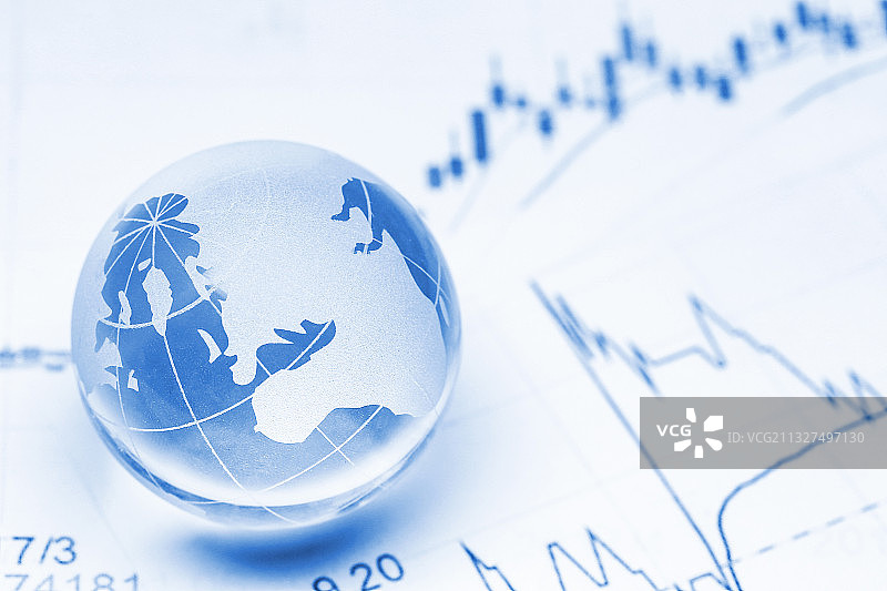 玻璃地球仪放在K线图背景上图片素材
