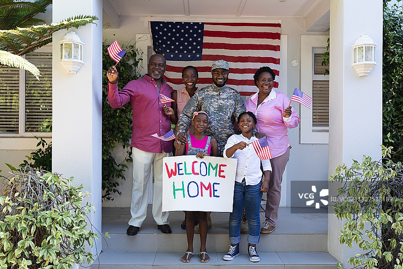 非裔美国士兵父亲与微笑的妻子、孩子和父母在他家门前图片素材