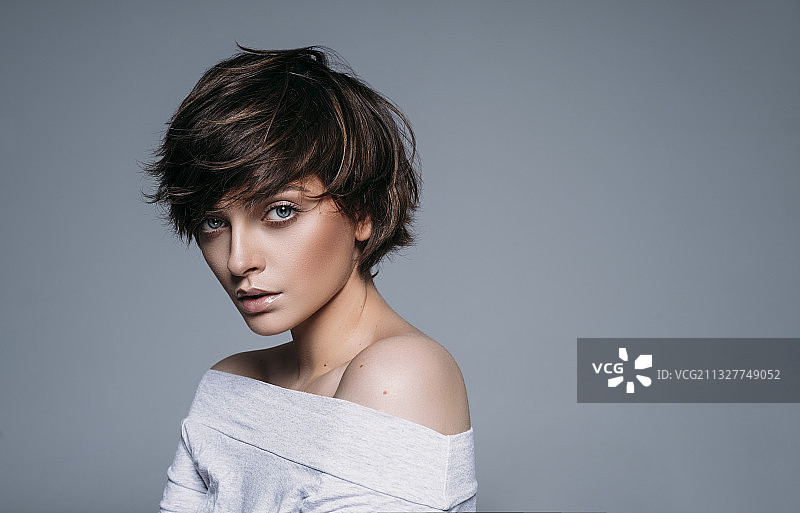 蓝色背景上的短发年轻女模特肖像图片素材