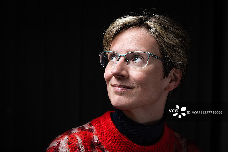 戴眼镜微笑女人黑色背景特写图片素材