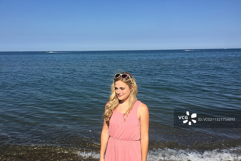 站在美国海滩边，以水为背景的女人肖像图片素材