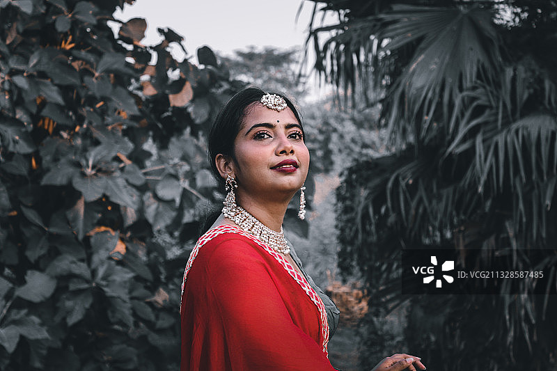 站在植物前的年轻女子肖像图片素材